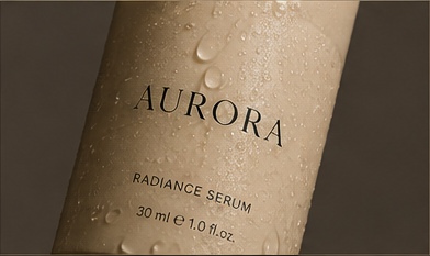 The AURORA radiance serum bottle in close up, beaded with water