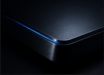 The edge of a dark device catching a thin blue rim light